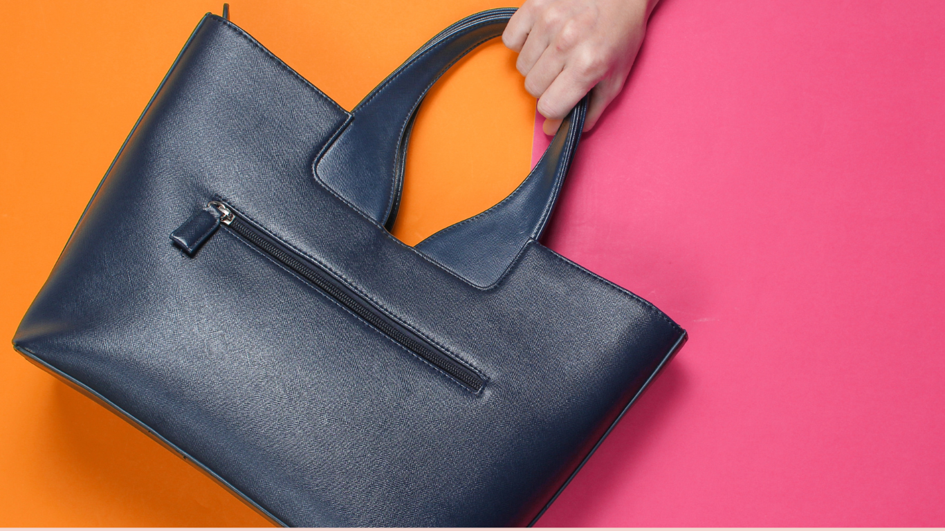 A sleek leather bag against a vibrant colorful background, highlighting modern accessory trends.