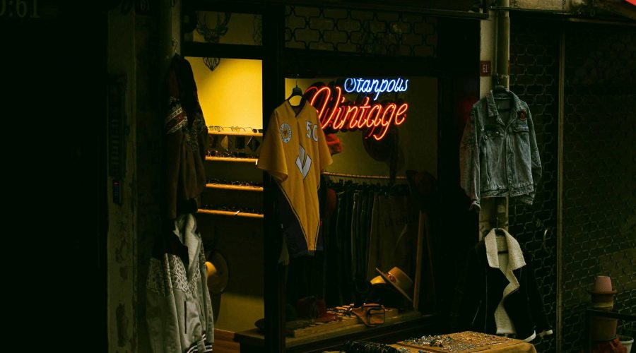 Vitrine d'une boutique, de nuit, avec une lampe néon qui indique "vintage".
